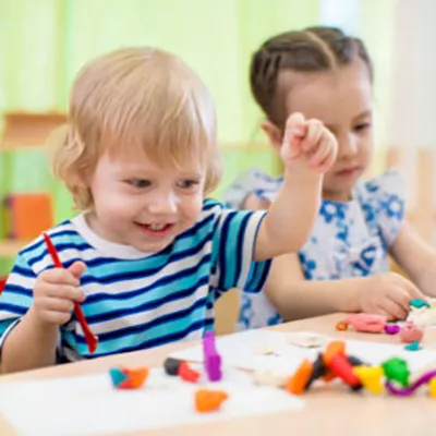 Niños felices haciendo manualidades. Niños en la guardería.