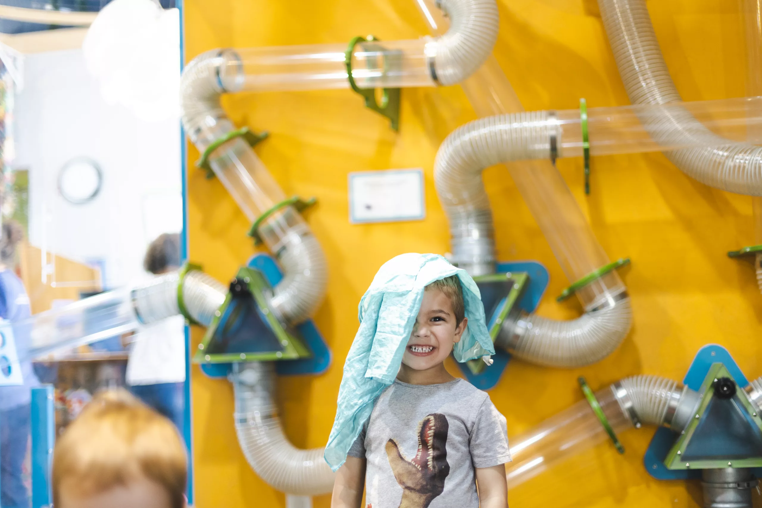 Child with silk scarf on head at the Children's Museum of Sonoma County AirMazing Exhibit 