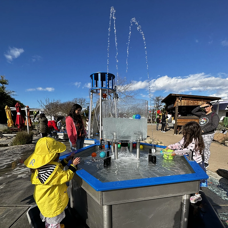 children happily playing with the Mechanical Waterways 2.0 Waterplay Exhibit at the Children's Museum of Sonoma County