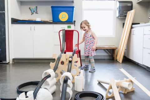 A young child playing with a large scale Marble Run Obstacle course at the Children's Museum of Sonoma County