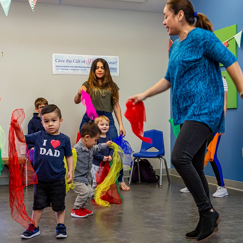 Guadalupe from Colors of Spanish dancing and singing with children during the Cuentos con Ritmo program at the Children's Museum of Sonoma County.