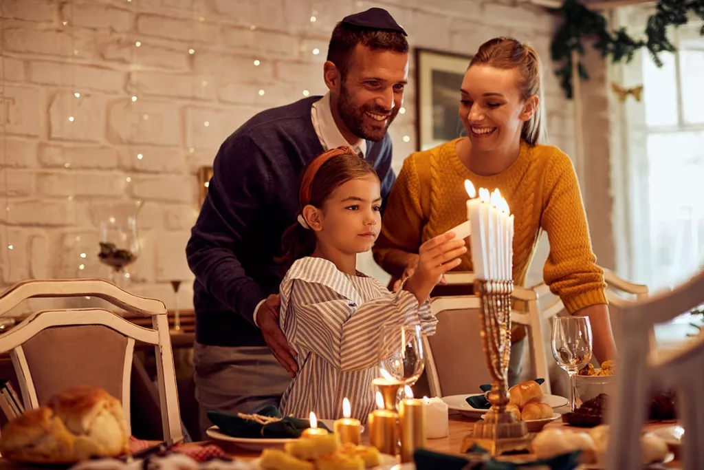 A Jewish family happily lighting the Menorah in celebration of Hanukkah.