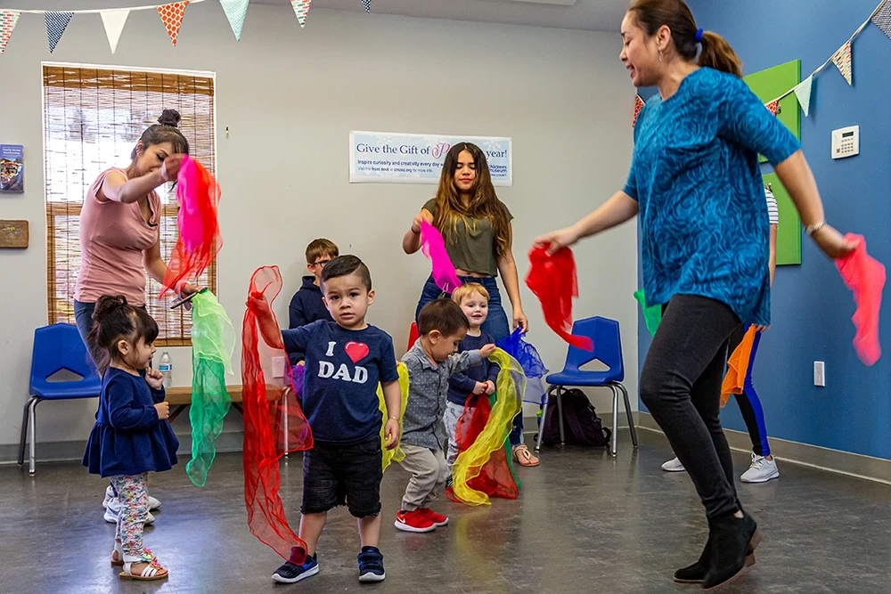 Niños de 1 a 5 años participan felices en Cuentos con Ritmo, un programa de lenguaje infantil del Museo Infantil del Condado de Sonoma.