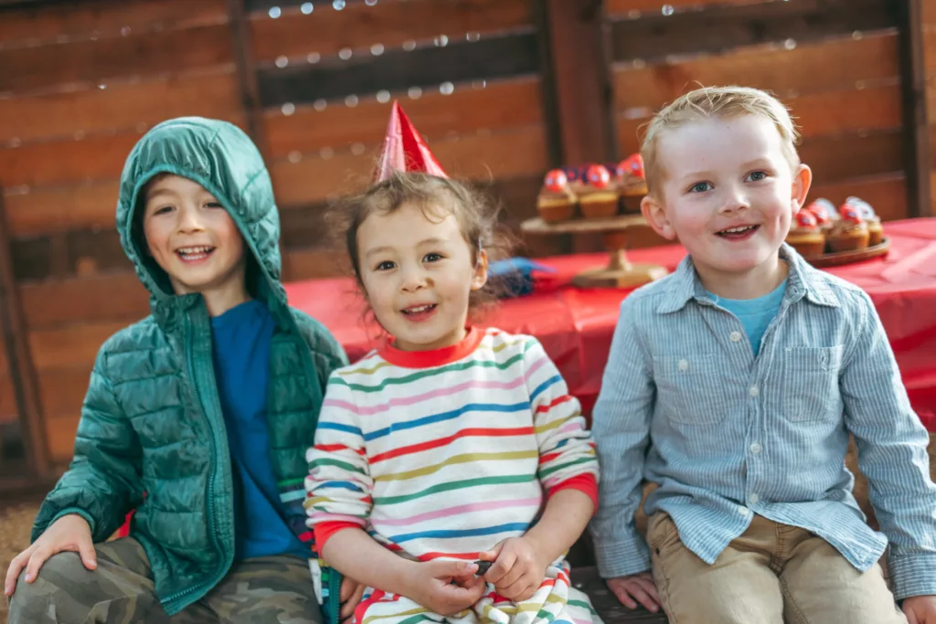 children sitting side by side at the Children's Museum for a birthday party