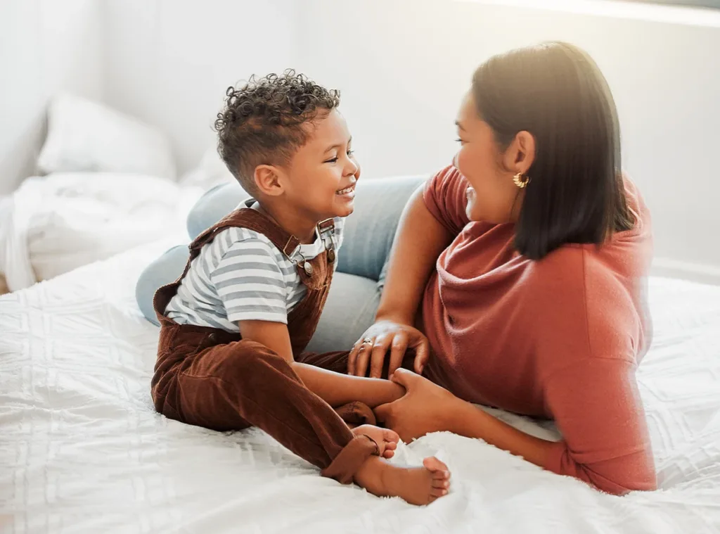 A mother and toddler at home smiling at each other while they spend quality time together 
