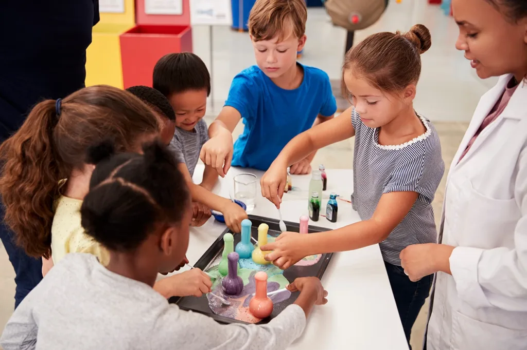 Six young children doing the Bubbling Witches Brew Halloween Science Experiments for Kids.