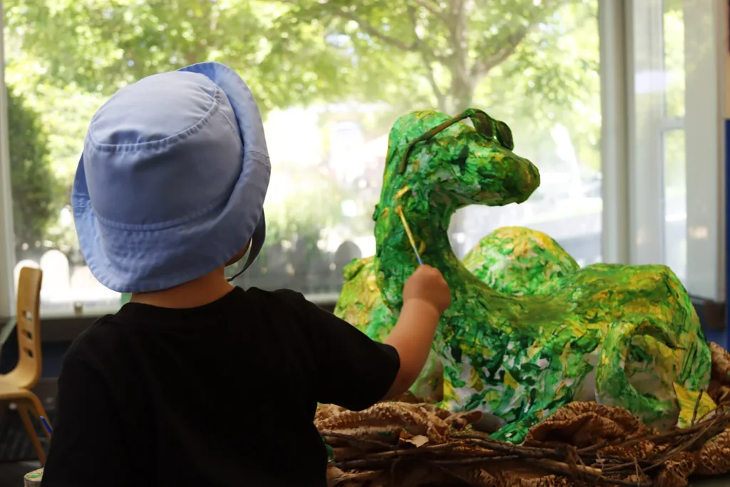 A child painting a paper mache dinosaur, a collaborative art project for all Children Museum visitors to enjoy. Picture taken at the 2025 Dino Trax event at the Children’s Museum of Sonoma County in Santa Rosa, CA.