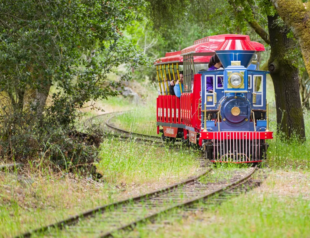 Children and their caregivers happily riding the Howarth Park Train ride at Howarth Park in Santa Rosa, CA