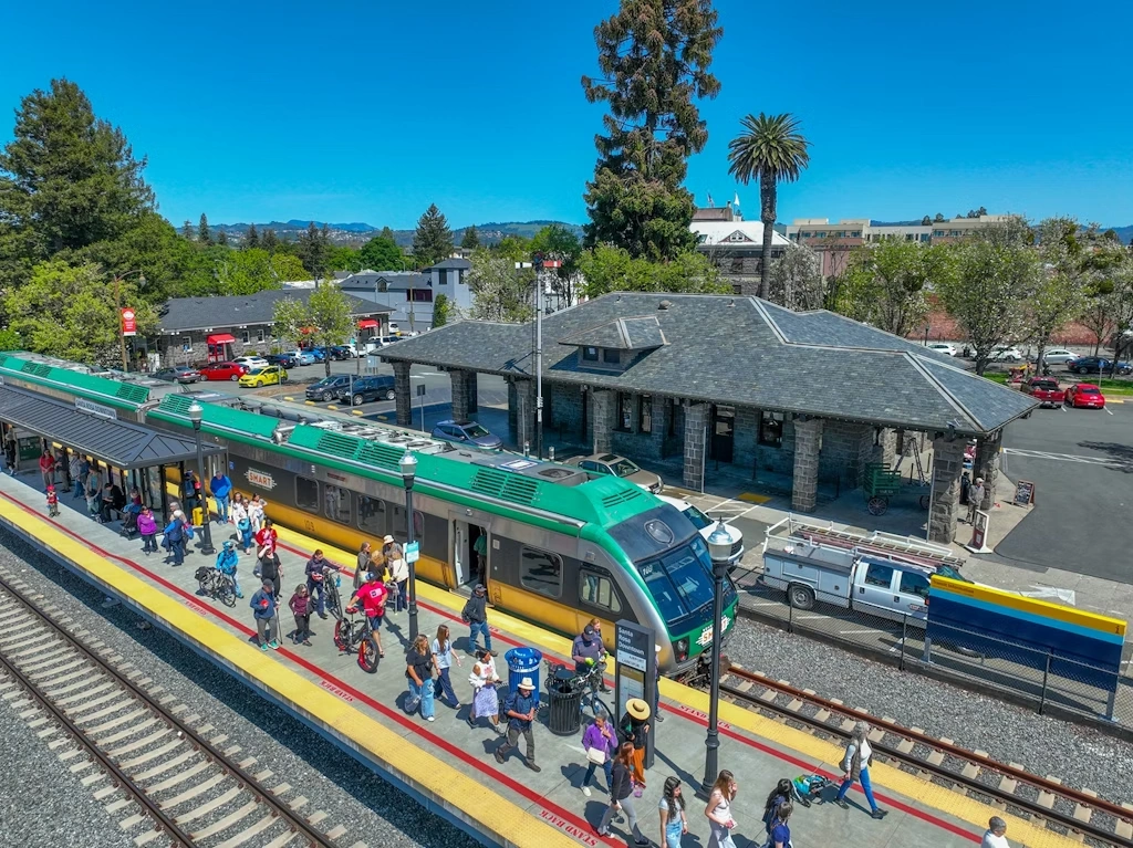 An aerial view of multiple passengers exiting the Sonoma-Marin SMART Train at the Santa Rosa Downtown Station in Santa Rosa, CA.