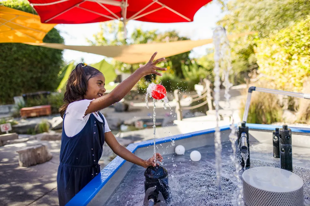 Un niño pequeño juega en una exposición al aire libre llamada «Mechanical Waterways 2.0» en el Museo de los Niños del Condado de Sonoma.