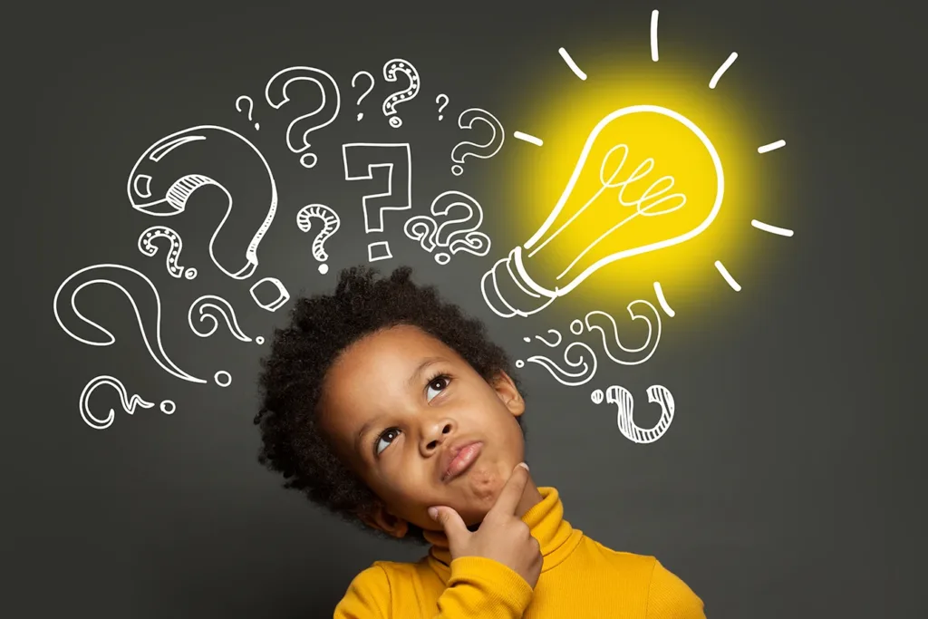 A young child making a thinking face with a light bulb and question marks around them.